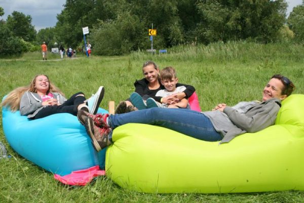 gezin zit ontspannen in het gras tijdens uitje