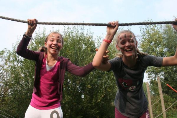 Meisjes op touwbrug tijdens introductiedag scholen